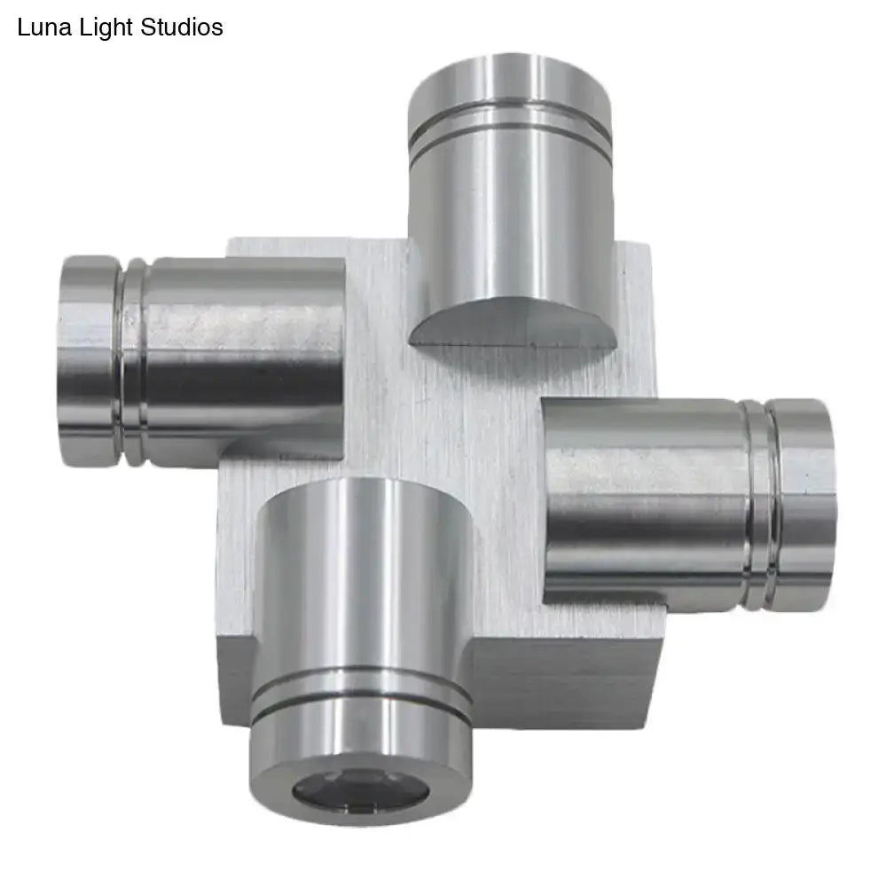Silver brushed finish cross aluminum wall mount lamp featuring a metallic cross-shaped component with cylindrical ports