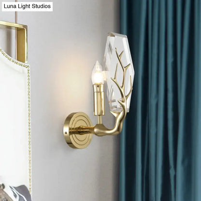 Modern style gold-toned direct wired electric sconce light with crystal antler design and faceted glass shade