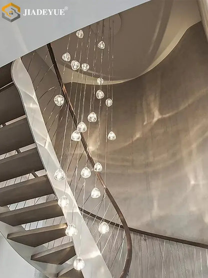 A modern crystal ball nordic led chandelier with multiple spherical lights on a curved metal frame for staircase decor