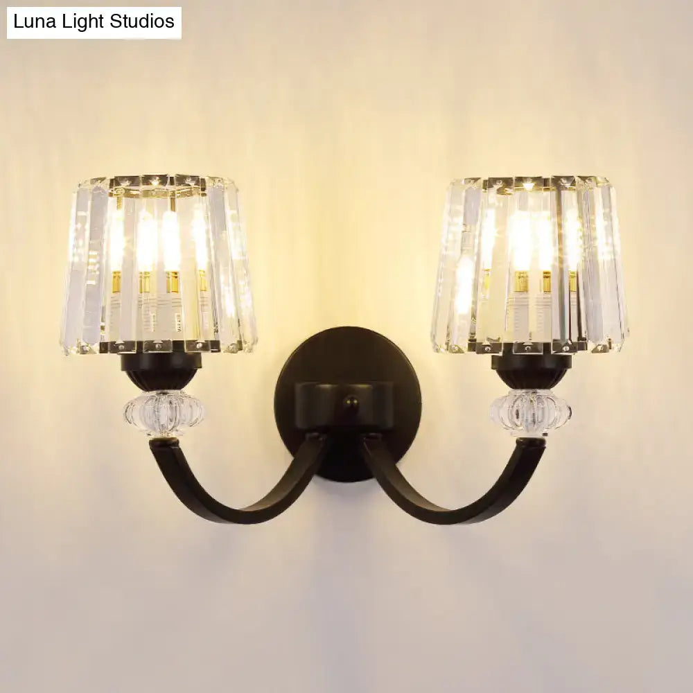 Black metal wall lamp with curved arm and two crystal-encased light fixtures in black gold finish for bedroom lighting