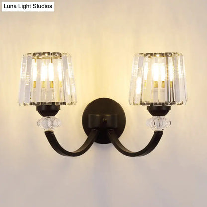 Black metal wall lamp with curved arm and two crystal-encased light fixtures in black gold finish for bedroom lighting