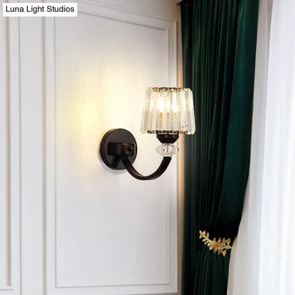 Black gold wall lamp with wrought iron curved arm and crystal chandelier-style shade for bedroom lighting