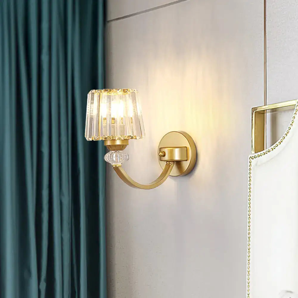 Modern black gold wall lamp with curved arm featuring a gold-toned sconce and crystal fringed shade with clear bead