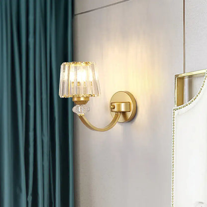 Modern black gold wall lamp with curved arm featuring a gold-toned sconce and crystal fringed shade with clear bead