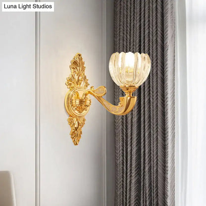 Modern crystal block gold wall lamp fixture featuring a gold-toned ornate sconce with fluted translucent glass shade