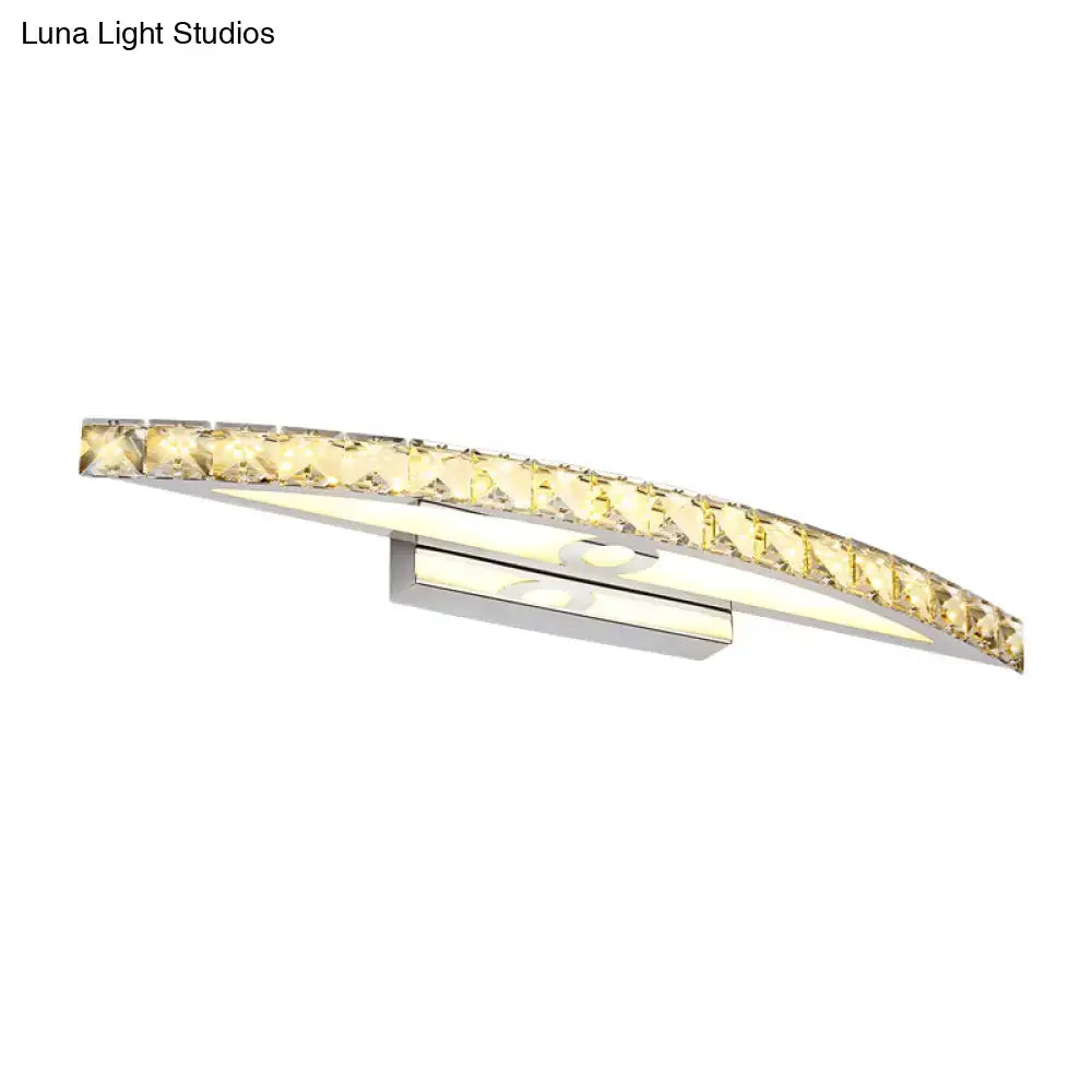 Curved led bathroom light fixture with clear champagne faceted crystal accents and a sleek chrome base emitting warm glow