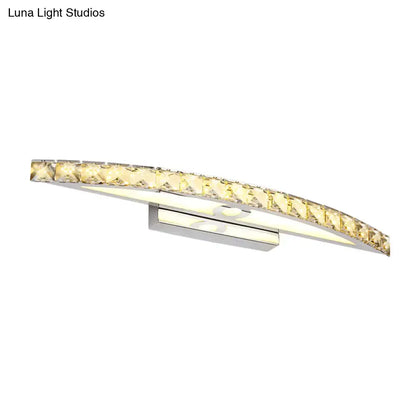 Curved led bathroom light fixture with clear champagne faceted crystal accents and a sleek chrome base emitting warm glow