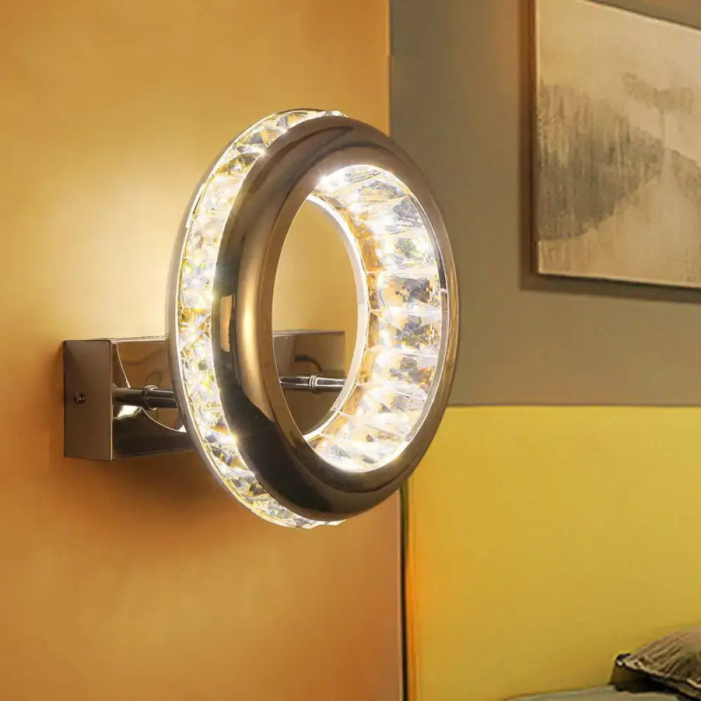 Modern crystal chrome sconce light fixture with stainless steel shade and clear crystals emitting warm illumination