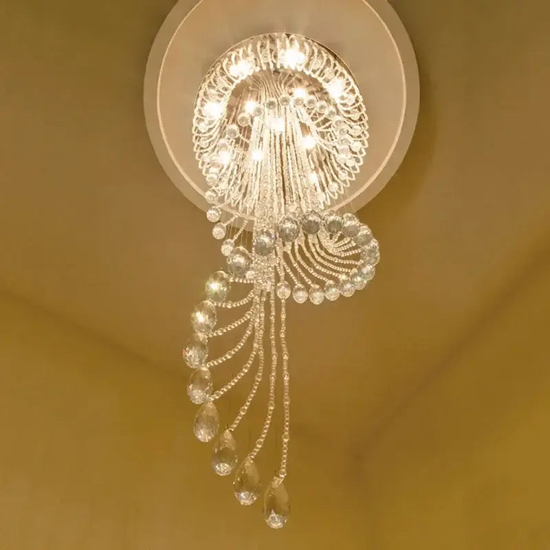A sparkling crystal modern double spiral staircase chandelier with circular ornate design and teardrop crystals for living room