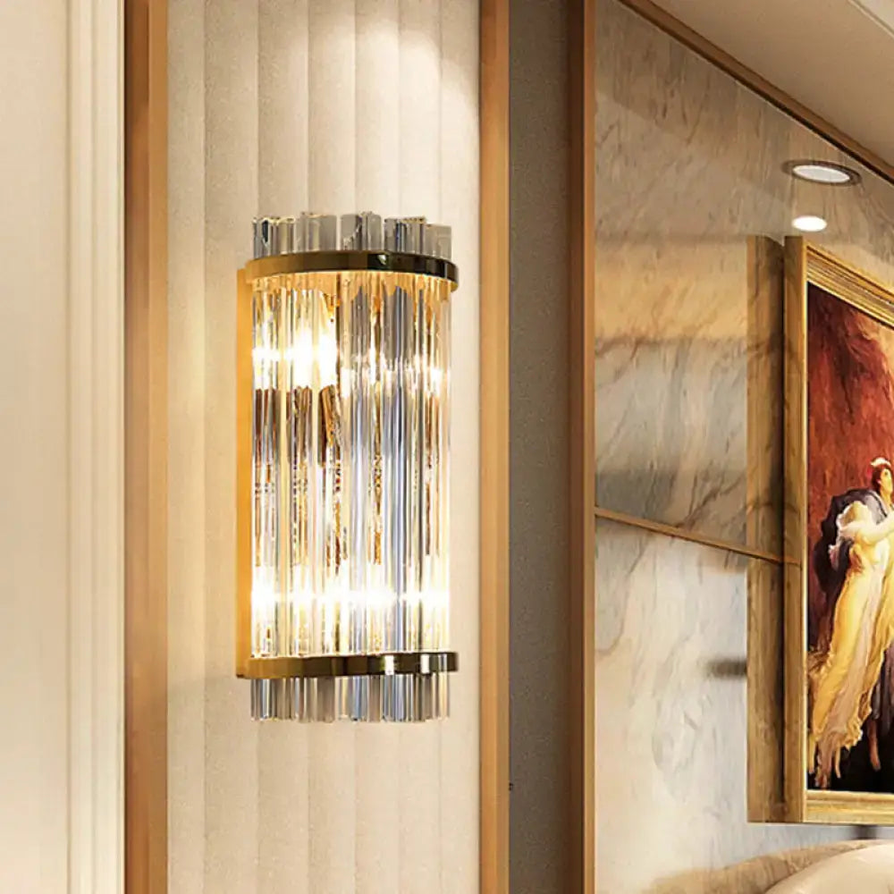 Modern crystal gold finish wall lighting sconce with vertical rods in gold finish metal frame emitting warm light