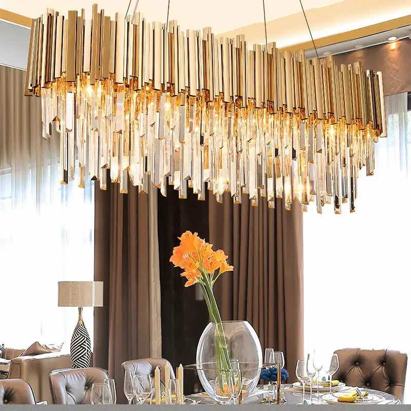 Modern crystal gold metal led pendant lights feature a gold-toned rectangular chandelier with cascading crystal rods and warm lights