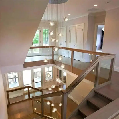 Modern glass and wood staircase with decorbites crystal led ceiling chandelier featuring clear spherical glass globes