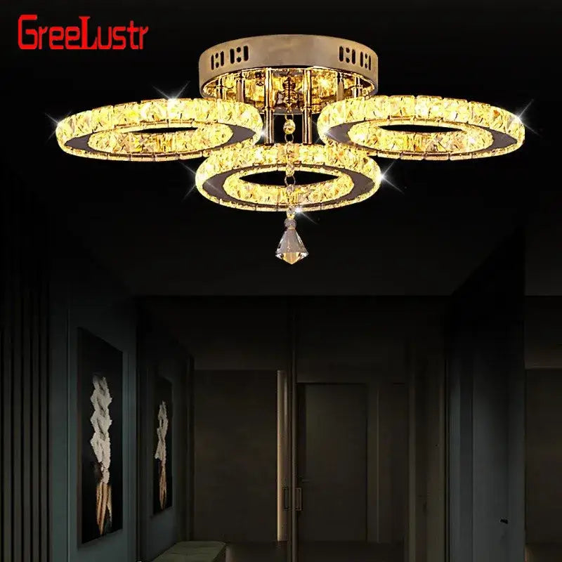 Modern gold-toned crystal led ceiling light with three interlocking rings and a faceted pendant for living room use