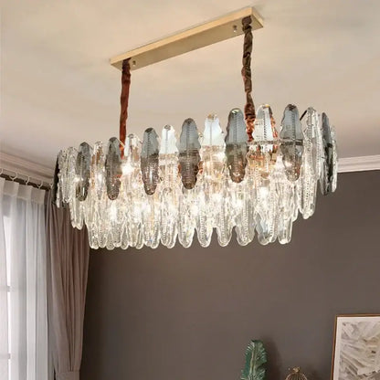 A modern decorbites crystal led chandelier with cascading clear and frosted glass teardrop prisms in gold frame