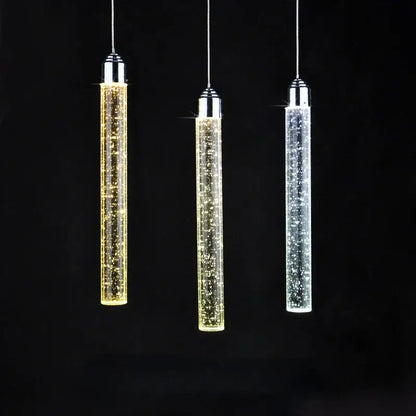 Three modern cylindrical decorbites crystal led pendant lights with chrome tops and glowing clear glass for dining room decor