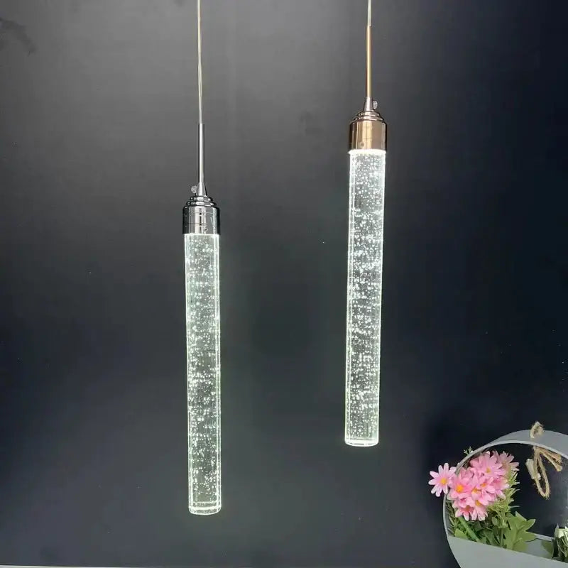 Two modern cylindrical decorbites crystal led pendant lights with clear glass and metallic tops for dining room decor