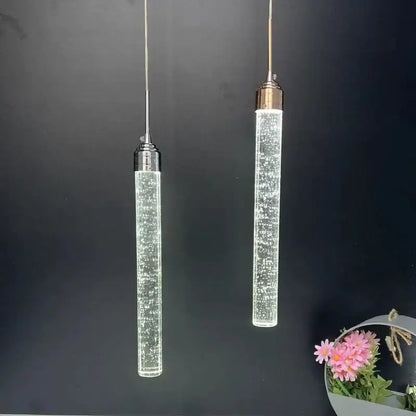 Two modern cylindrical decorbites crystal led pendant lights with clear glass and metallic tops for dining room decor