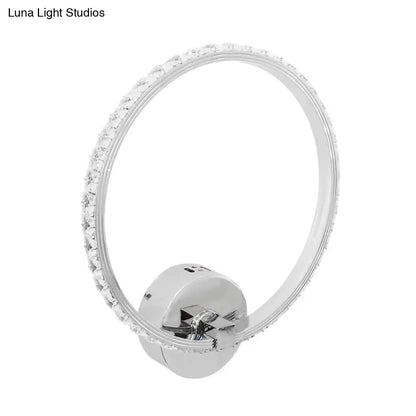 A sleek modern crystal led wall sconce with chrome finish and clear crystal embellishments for bedroom lighting