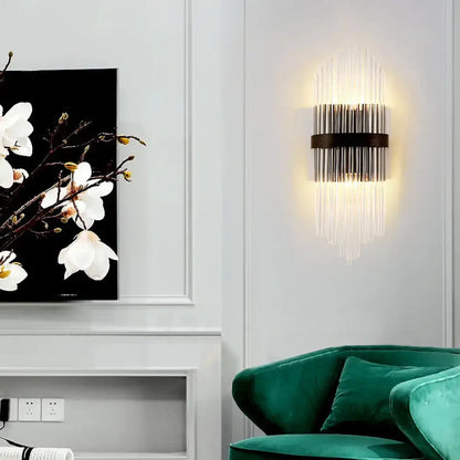 Modern crystal prism wall sconce with sleek black metal frame and metal square backplate emitting warm light