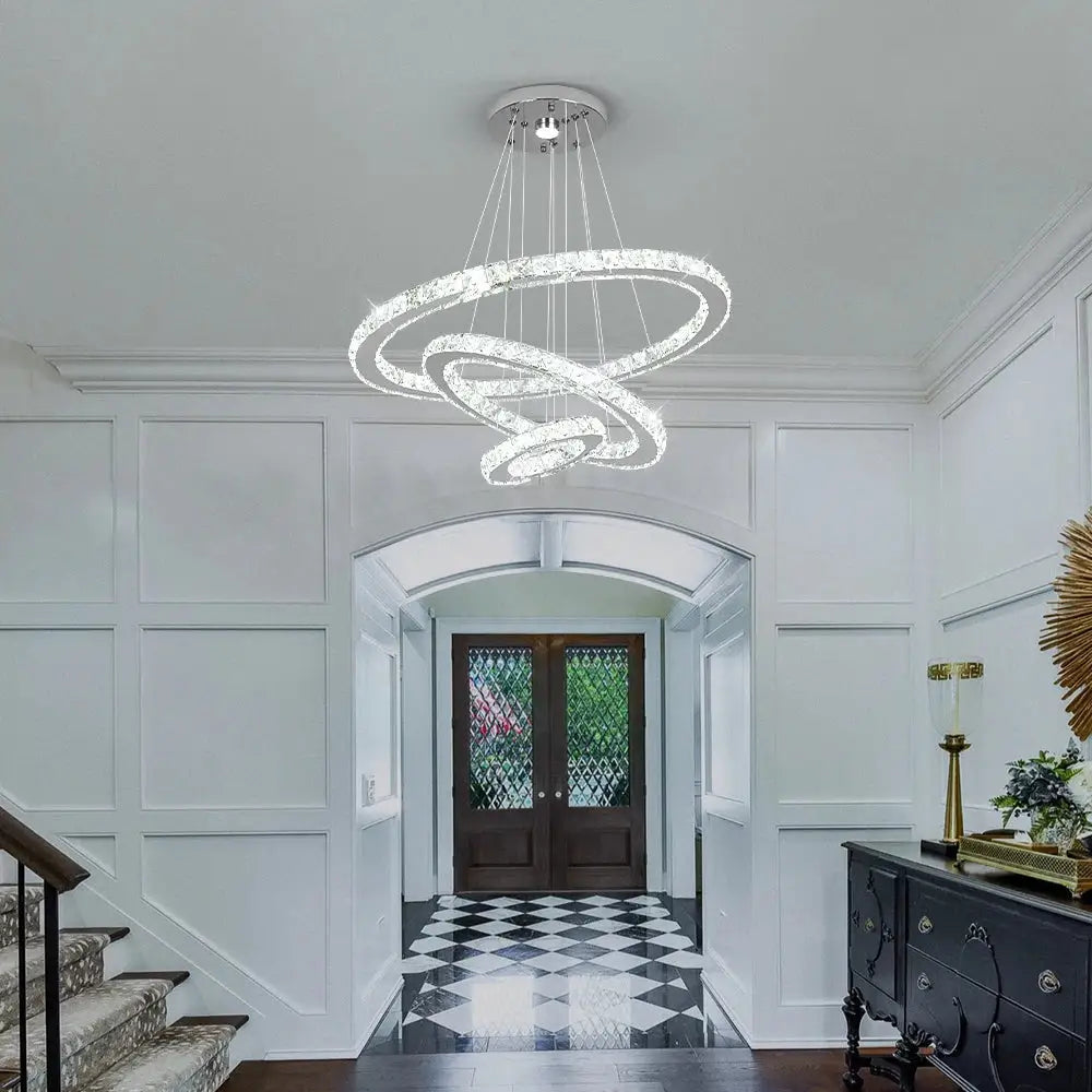 A modern crystal rings led pendant light featuring multi-tiered interlocking rings chandelier for dining room decorbites