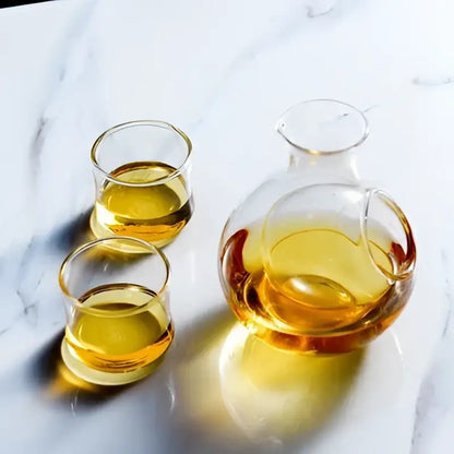 Clear glass crystal sake ice jug with rounded body and handle filled with amber liquid for dining room decorbites crystal sake