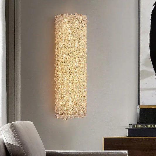 Modern crystal wall lamp featuring a tall rectangular gold sconce with sparkling clear crystals emitting warm glow