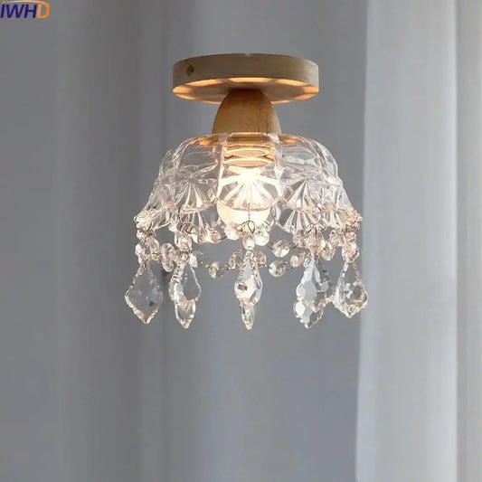 A modern decorbites crystal wood led ceiling lamp with clear teardrop crystals and a wooden base for bedroom decor