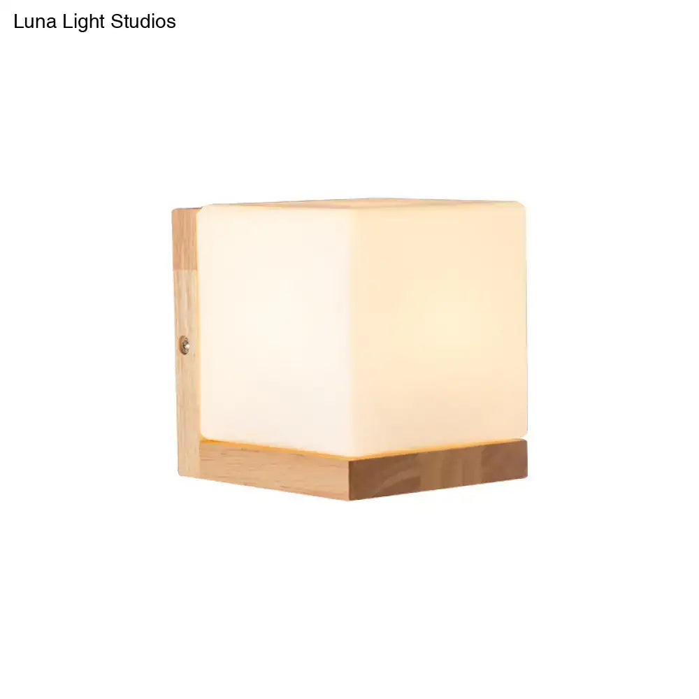 Modern cube shaped sconce wall lamp with warm frosted acrylic face and wooden backplate for bedroom lighting