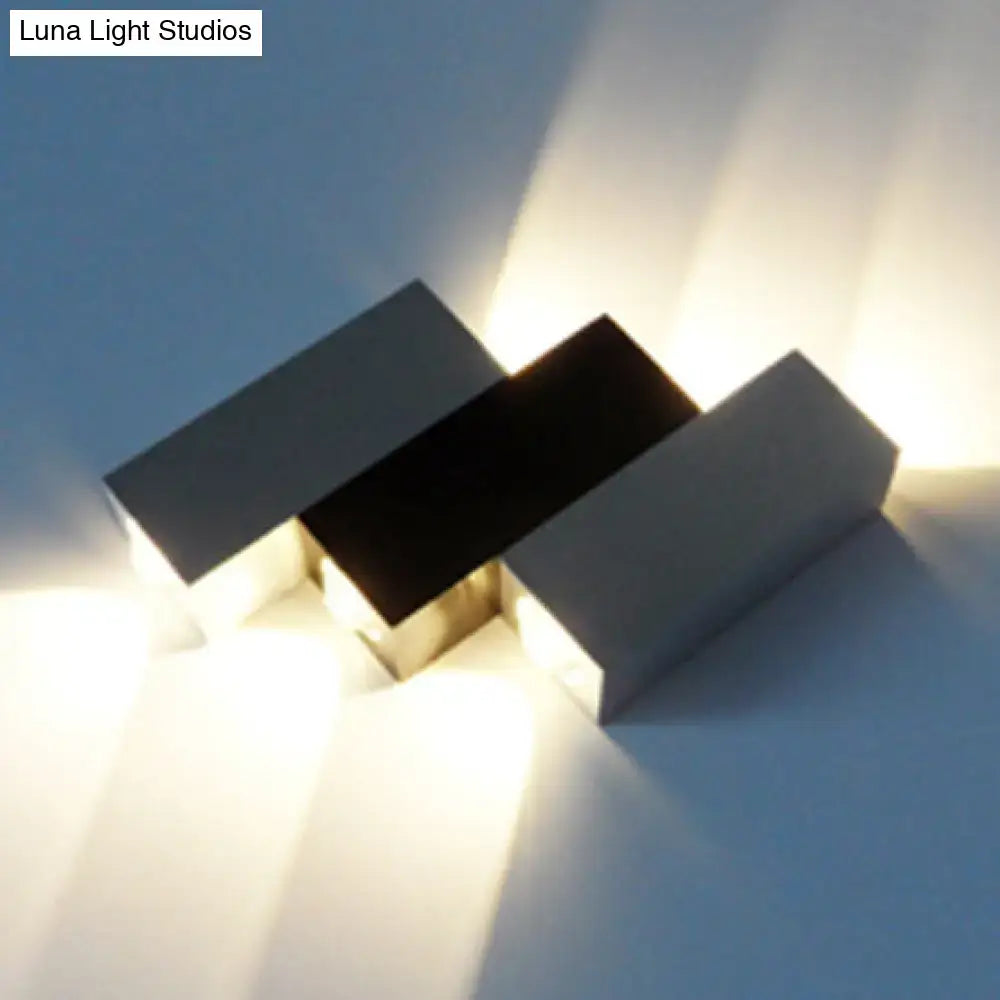Modern cubic silver and black wall sconce with three matte rectangular panels for direct wired electric porch use