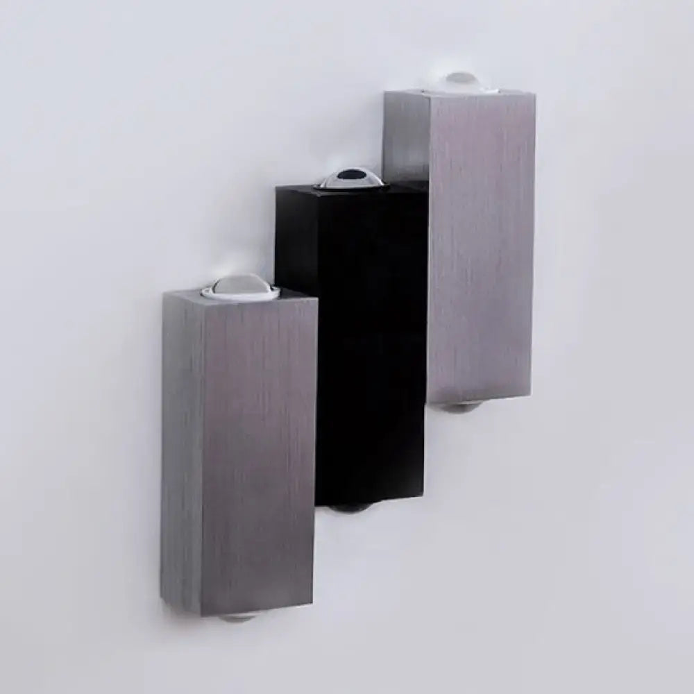 Three modern cubic silver and black wall sconces with brushed metallic finish and direct wired electric setup