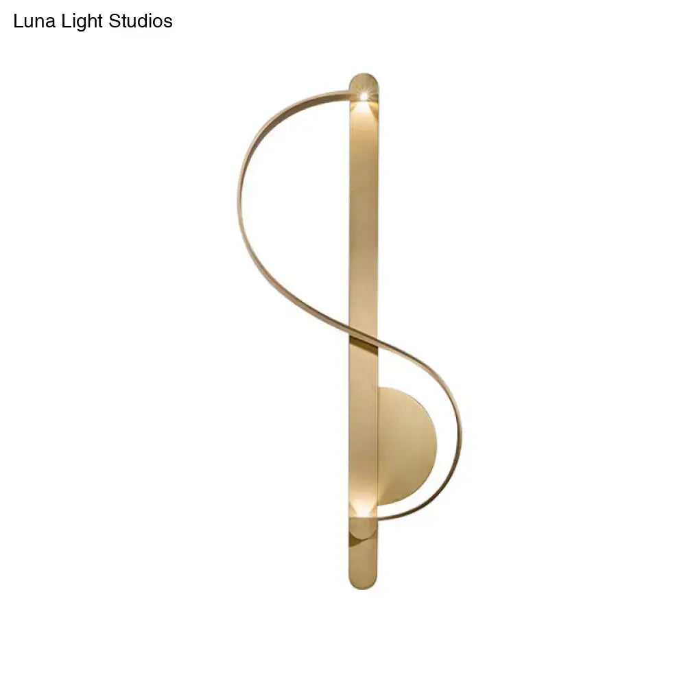 Gold-toned minimalist wall sconce with sleek curved design featuring warm white integrated lighting for bedroom use