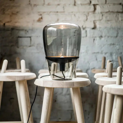 A sleek modern decorbites glass table lamp with a transparent body and black base for bedroom led lighting
