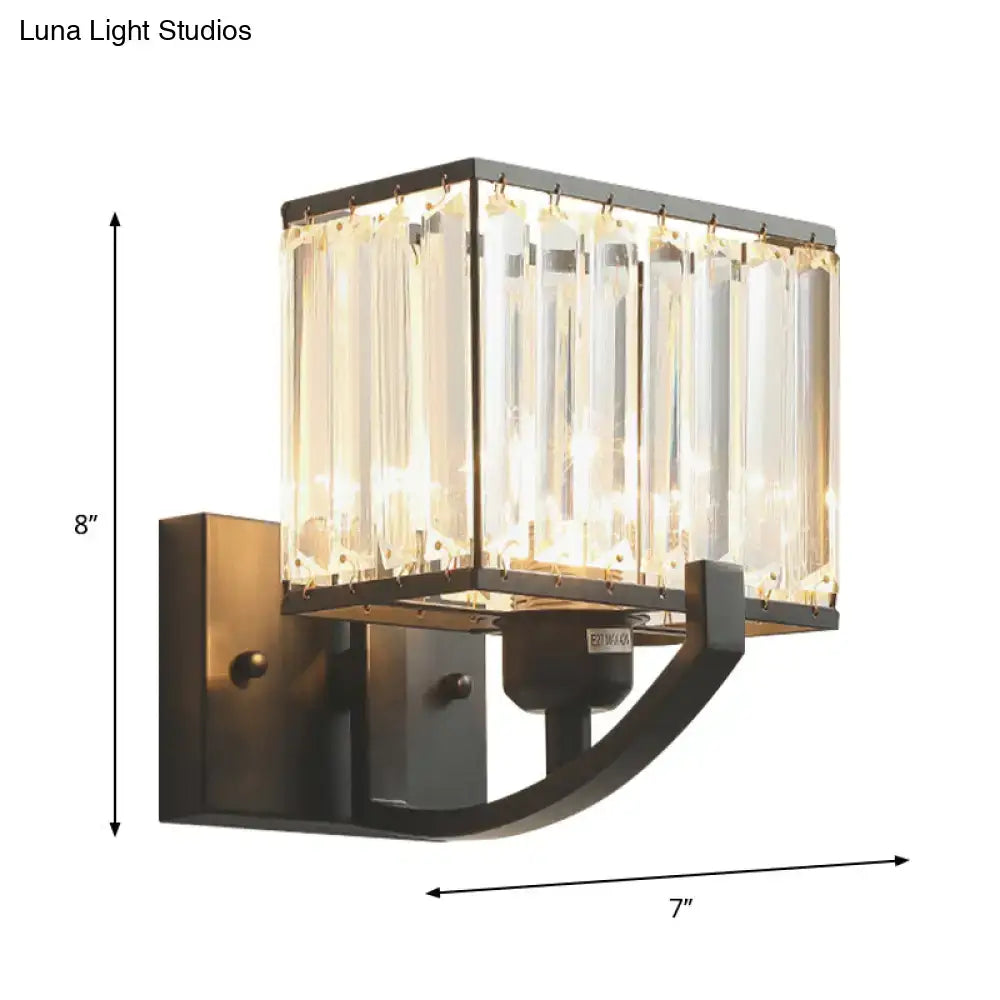 Modern dark bronze wall mount light featuring a rectangular frame with crystal prisms emitting warm light for bedrooms