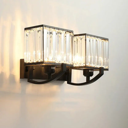 Modern dark bronze wall mount light with black metal frames and clear crystal prisms for bedroom sconce lighting