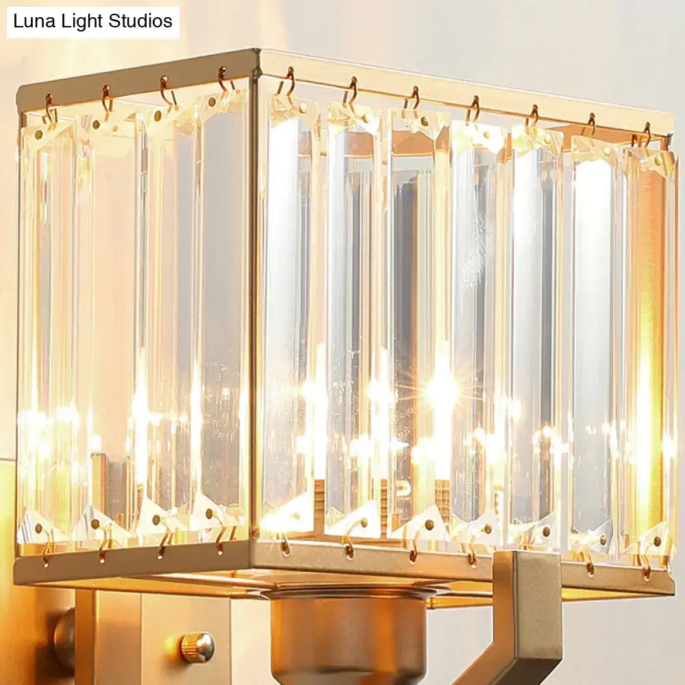 Modern dark bronze wall mount light featuring a gold-toned rectangular frame with clear crystal prisms