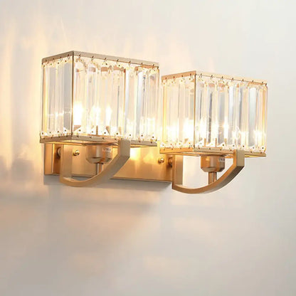 Gold-toned modern dark bronze wall mount light with two rectangular crystal glass shades for bedroom use