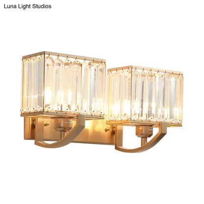 Gold-toned modern wall mount light with two rectangular crystal-encased fixtures for bedroom sconces