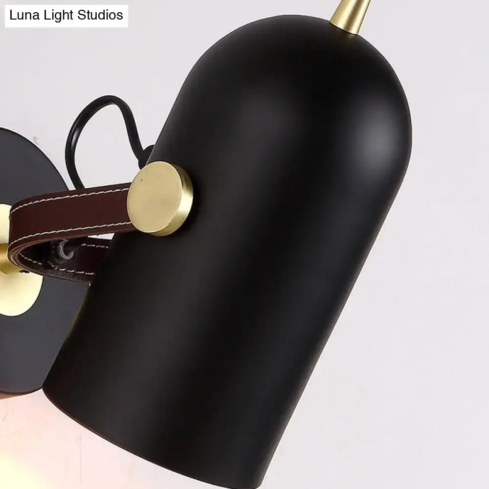 Modern wall lamp with black matte finish brass accents brown leather strap and cup shade for office corridor use