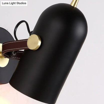 Modern wall lamp with black matte finish brass accents brown leather strap and cup shade for office corridor use