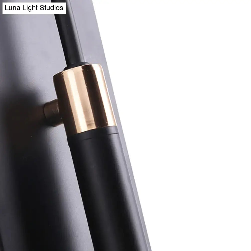 Black and brass-finished modern wall lamp with sleek cylindrical design and conical shade for living room use