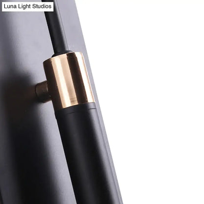 Black and brass-finished modern wall lamp with sleek cylindrical design and conical shade for living room use