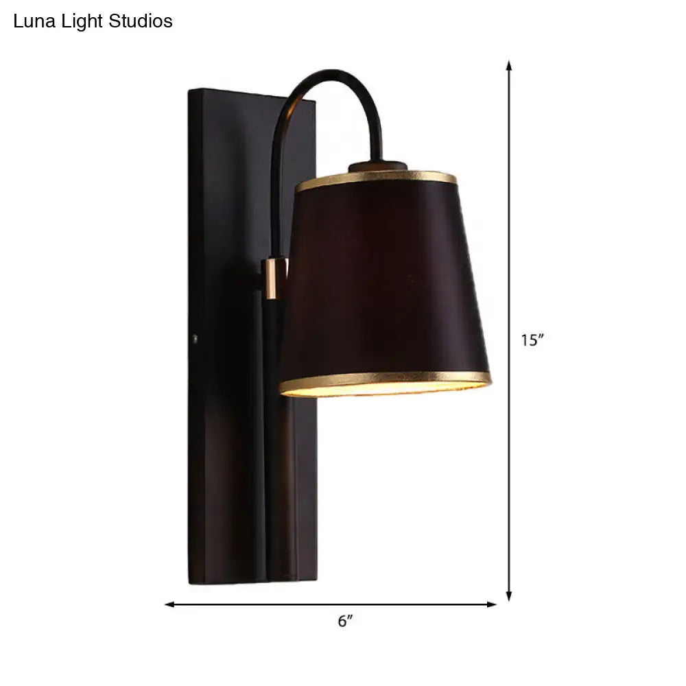 Modern dark brown fabric wall lamp with gold trim and conical shade mounted on black metal fixture for living room