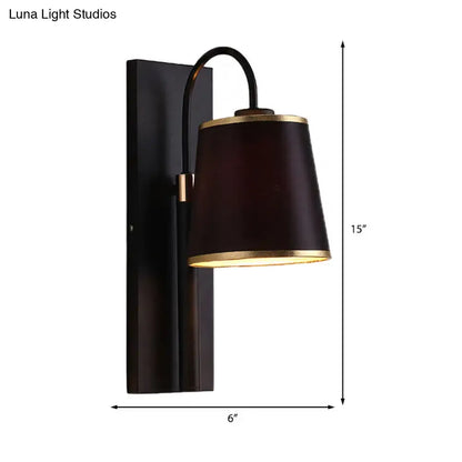 Modern dark brown fabric wall lamp with gold trim and conical shade mounted on black metal fixture for living room