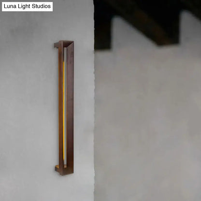 A modern dark brown wooden led wall sconce with a sleek frame and warm yellow vertical illumination for study rooms