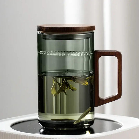 Modern dark green glass tea cup set with wooden handle and lid featuring a sleek transparent design for dining room use