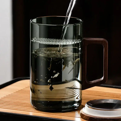 Modern dark green glass tea cup set with clear glass teapot featuring dark wooden handle and subtle ridges