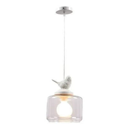 A white ceramic decorbites bird perched on a clear glass pendant of a bird led glass chandelier dining room light