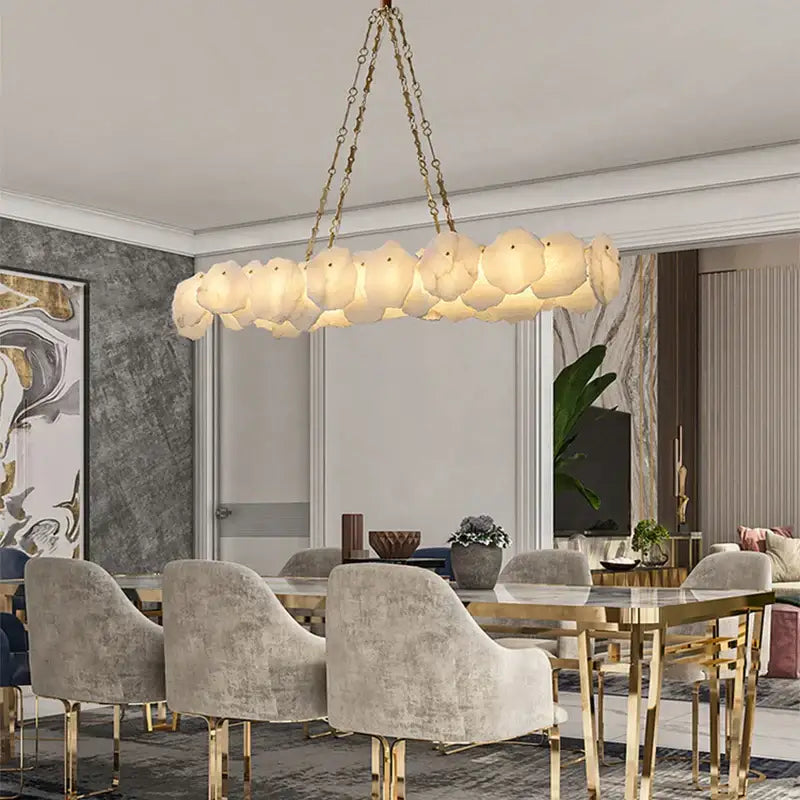 A modern decorbites brass marble ceiling chandelier with off-white cloud-like glass shades and gold-toned chains