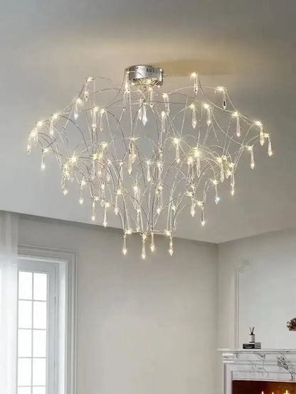 A modern silver-toned decorbites deluxe crystal star lamp with wire arms and crystal droplets emitting warm white light