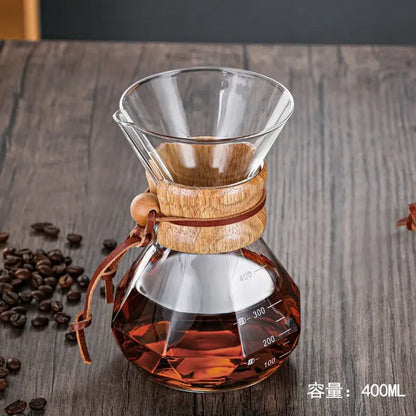 Modern decorbites glass coffee maker with wooden collar and leather tie filled with amber brewed coffee for kitchen drip